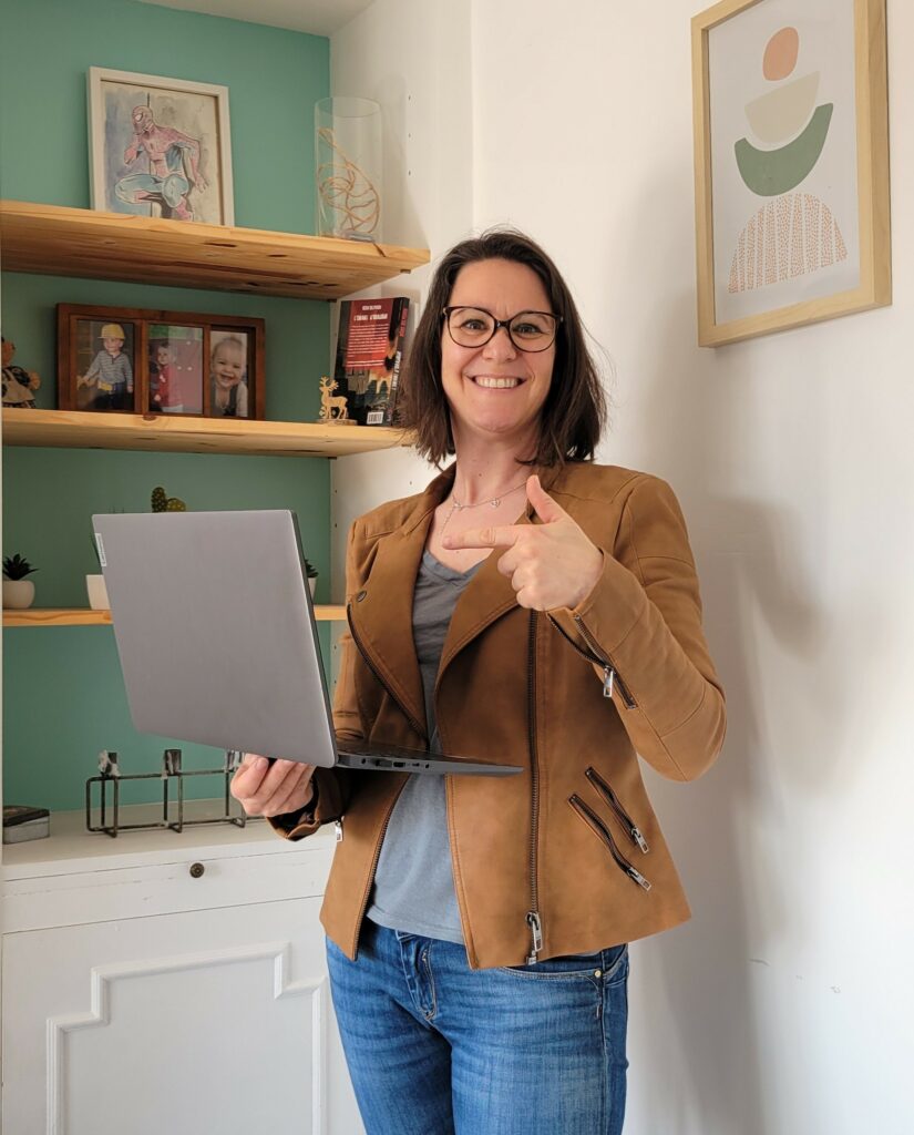 Élodie de SECRET’R, debout avec un ordinateur portable.